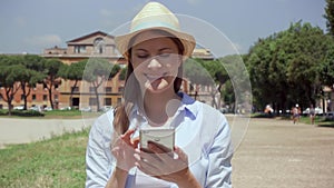 Woman using mobile phone in slow motion in Rome, Italy. Female traveler enjoying vacation in Europe