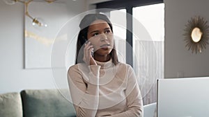 Woman using mobile phone and standing infront of desk at home office