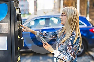 Woman using a mobile phone to pay for parking in the city