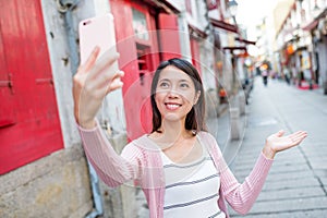 Woman using mobile phone to take selfie photo