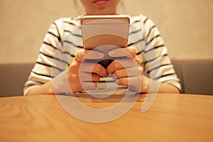 woman using mobile phone and waiting alone in restaurant background with copy space
