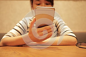 woman using mobile phone and waiting alone in restaurant background with copy space