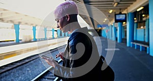 Woman using mobile phone while waiting for train 4k