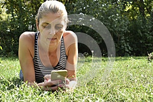 Woman using mobile smart phone in the park