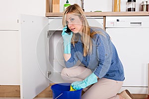 Woman Using Mobilephone Near Kitchen Sink