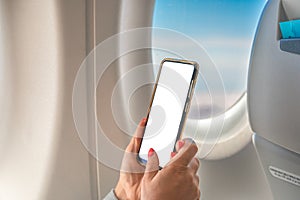 Woman Using mockup Mobile Phone While Sitting In Airplane. Woman using smartphone in airplane during flight. woman Hands using