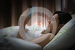 Woman with using modern devices on screen before sleep.
