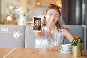 Woman using modern mobile smart phone connecting to wifi automation apps. Remote virtual control at home.