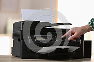 Woman using modern printer in office, closeup