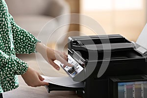 Woman using modern printer in office, closeup