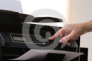 Woman using modern printer in office, closeup