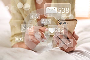 Woman using modern smartphone on bed, closeup. Social media marketing