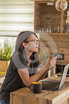 Woman using modern technologies while telecommuting