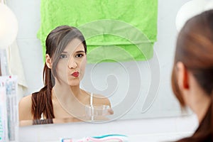 Woman using mouthwash