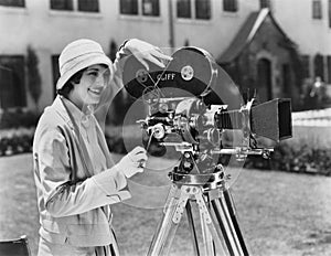 Woman using movie camera outdoors