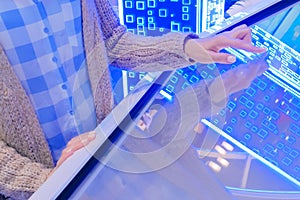 Woman using multimedia touchscreen display of interactive kiosk
