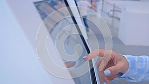 Woman using multimedia touchscreen display of interactive kiosk at exhibition