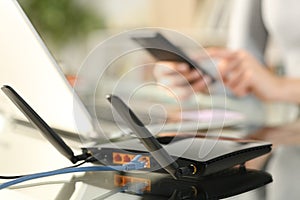 Woman using multiple devices with broadband router on foreground