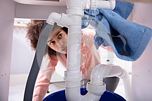 Woman Using Napkin Under Leakage Sink Pipe