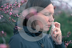 Woman using nasal spray outdoors