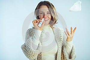 Woman using nasal spray and throwing up with napkin