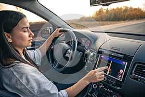 Woman using navigation system while driving a car.