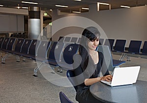 Woman Using Notebook in the Airport Terminal