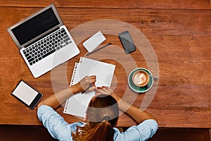 Woman Using Notebook Computer, Taking Notes At Cafe. Working.