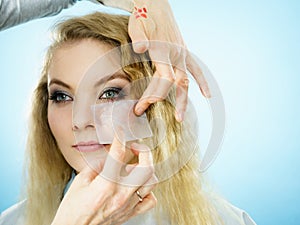 Woman using oil blotting tissues on model photo