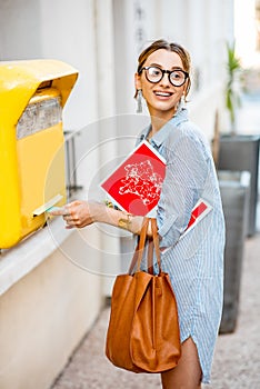 Woman using old mailbox outdoors