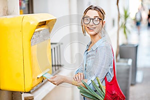 Woman using old mailbox outdoors