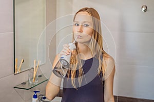 Woman using an oral irrigator in bathroom
