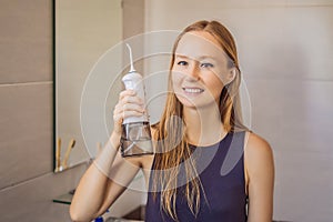 Woman using an oral irrigator in bathroom