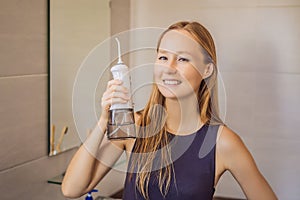 Woman using an oral irrigator in bathroom
