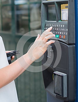 Woman using parking machine.