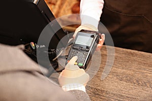 Woman using payment terminal at shop