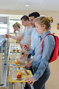 woman using phone in cafeteria