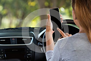 Woman using phone in car on road