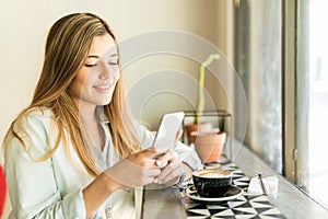 Woman using phone in a coffee shop