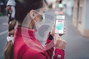 Woman using phone with the Coronavirus tracking app