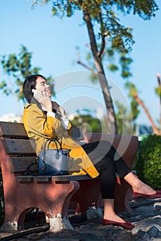 Woman using phone and laughing in a park