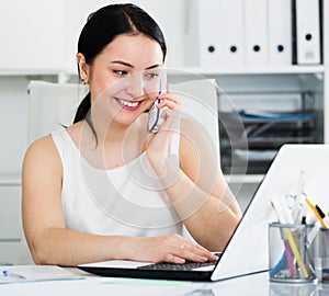 Woman using phone in office