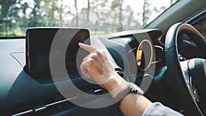 A woman using and pointing finger at navigation screen while driving car
