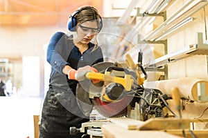 Woman using power tools in a woodshop photo