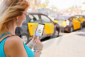 Woman using ride sharing app on phone