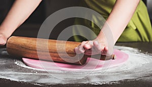 Woman using rolling pin preparing royal icing for cake decorating