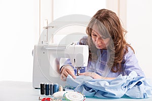 Woman using sewing machine photo