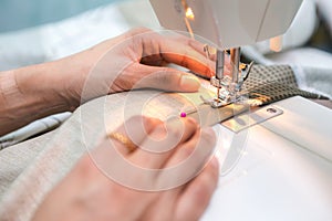 Woman is using sewing machine for bed sheets by oneself
