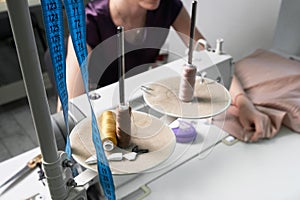 Woman using sewing machine in tailor studio, modern atelier shop