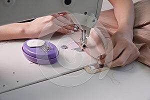 Woman using sewing machine in tailor studio, modern atelier shop